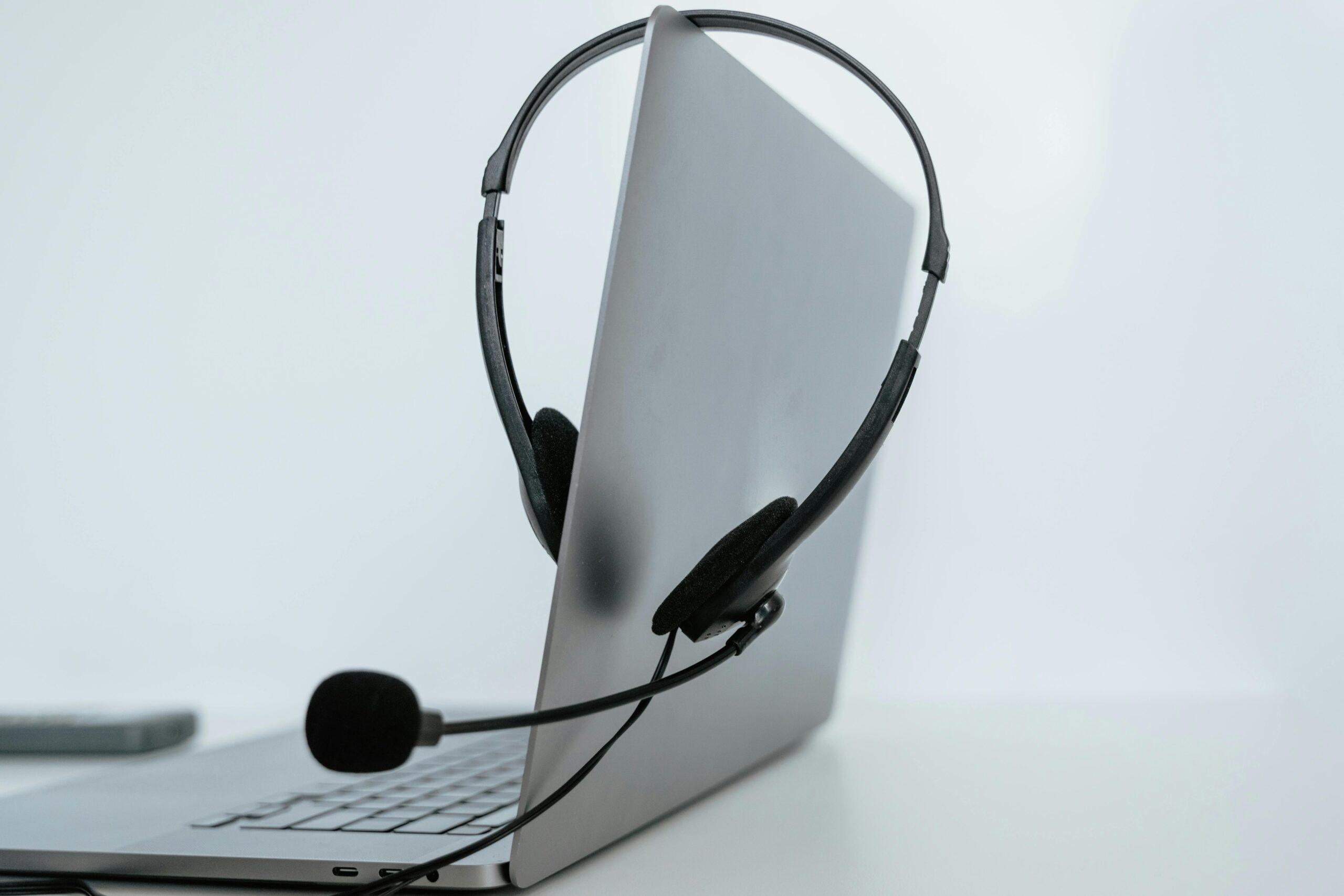 Close-up of a laptop with a headset, symbolizing remote work or online communication.